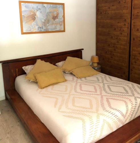 un lit avec deux oreillers dessus dans une chambre dans l'établissement Charmant Petit gite au milieu de la Verdure, à Coulounieix-Chamiers