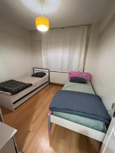 Habitación pequeña con 2 camas y suelo de madera. en Müslüm en Estambul
