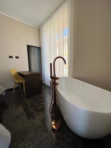 Viminale Domus في روما: حوض استحمام كبير أبيض في حمام مع طاولة