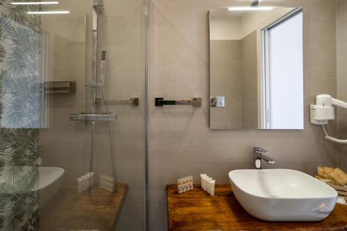 a bathroom with a sink and a shower with a mirror at Humboldt Luxury Rooms Taormina in Taormina
