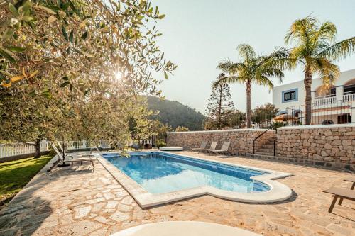a villa with a swimming pool and palm trees at Finca Norte, Amazing villa close to the best Beaches in Portinatx
