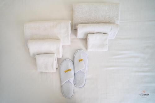 - une paire de tongs et de serviettes sur un lit dans l'établissement Humboldt Luxury Room Taormina, à Taormine