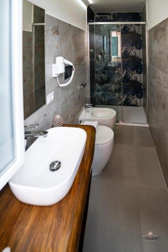 a bathroom with a sink and a toilet and a shower at Humboldt Luxury Rooms Taormina in Taormina