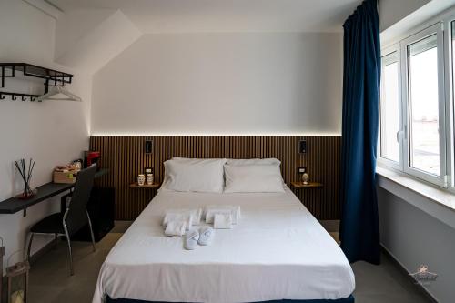 a bedroom with a bed with two towels on it at Humboldt Luxury Rooms Taormina in Taormina