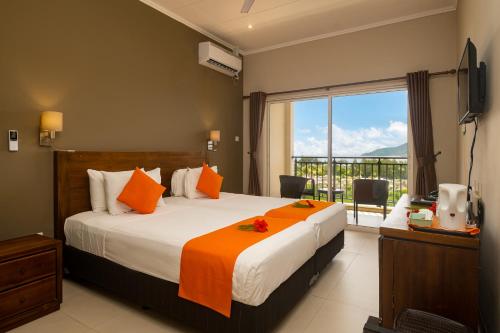 um quarto com uma cama grande e um cobertor laranja em The Ridge Residence em Victoria