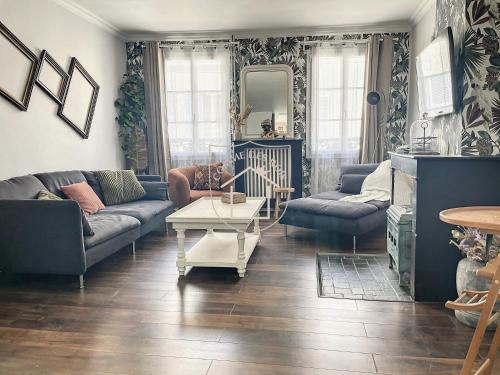 a living room with couches and a table at Le Donjon des Rois in Dourdan