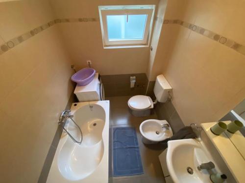 a bathroom with a tub and a toilet and a sink at Klementina in Mali Lošinj