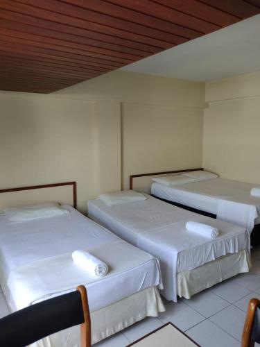 three beds in a room with white walls at Royal Service Hotel - Tambaú - ap 111 in João Pessoa