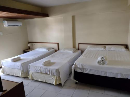 two beds in a hotel room with white sheets at Royal Service Hotel - Tambaú - ap 111 in João Pessoa
