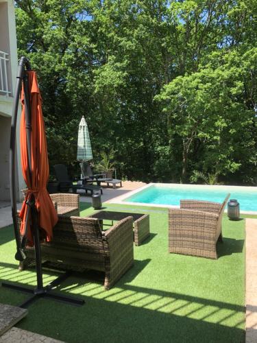 un parasol et des chaises à côté d'une piscine dans l'établissement Charmant Petit gite au milieu de la Verdure, à Coulounieix-Chamiers