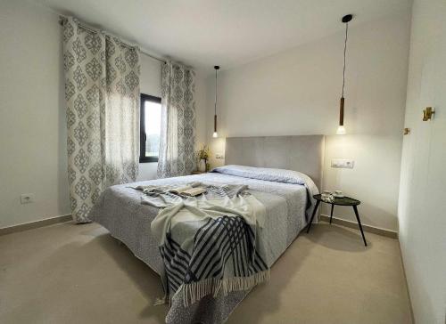 Schlafzimmer mit einem Bett und einem Fenster in der Unterkunft Can Candiu Establecimiento de 2 casas enteras in Vall-llobrega