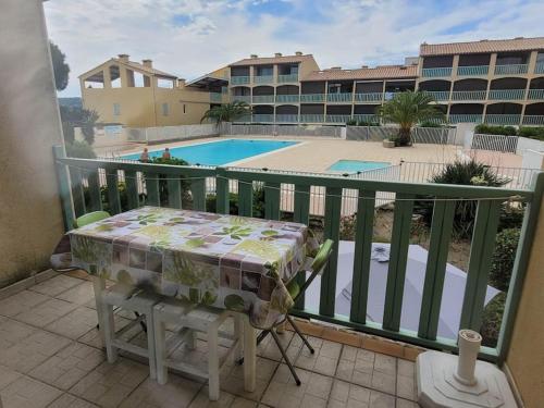 d'une table et de chaises sur un balcon avec piscine. dans l'établissement Studio Gruissan, à Gruissan