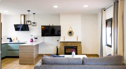a living room with a couch and a fireplace at Can Candiu Establecimiento de 2 casas enteras in Vall-Llobrega