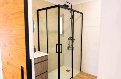 a shower with a glass door in a bathroom at Can Candiu Establecimiento de 2 casas enteras in Vall-Llobrega