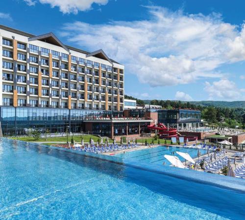 um hotel com uma grande piscina com espreguiçadeiras em Fruške Residences em Vrdnik