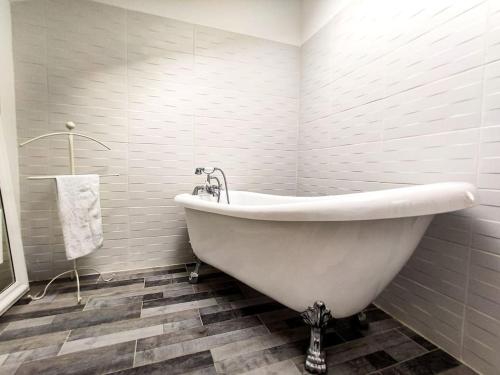 a white bath tub in a bathroom with tiles at Hyper Centre Fontainebleau Villa Beau Soleil in Fontainebleau