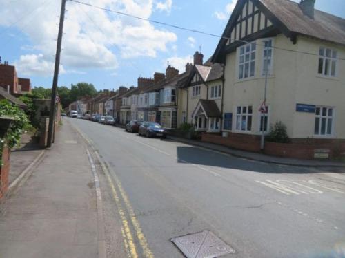 an empty street with a row of houses and cars at 2 Railway Terrace 