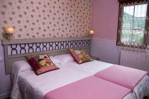 a bedroom with a bed with two pillows on it at Casa La Bolera in Carreña de Cabrales 