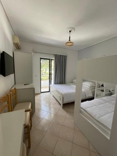 1 Schlafzimmer mit 2 Betten, einem Schreibtisch und einem Stuhl in der Unterkunft Hotel MS in Sarandë