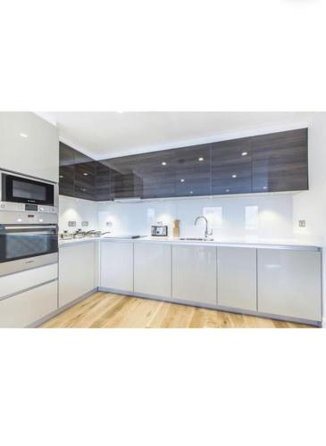 una grande cucina bianca con armadi e elettrodomestici bianchi di SweetHome Luxury Apartment a Londra