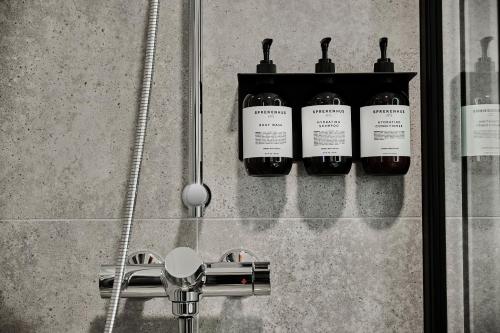 a group of five bottles of soap in a shower at Hotel Filip in Oslo