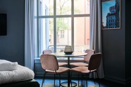 a table and chairs in a room with a window at Hotel Filip in Oslo
