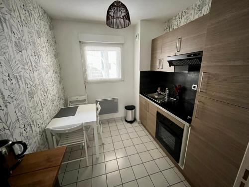 uma pequena cozinha com mesa e bancada em Chouette Appartement Dijon Centre em Dijon