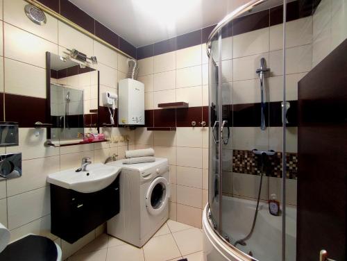a bathroom with a washing machine and a sink at Parkcity Chorzów in Chorzów