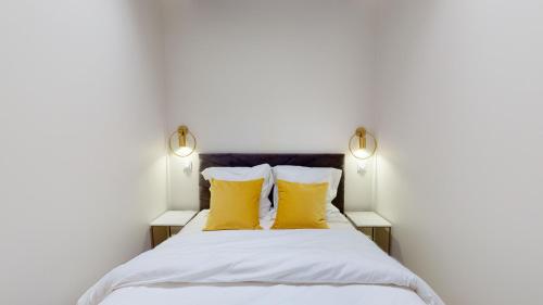ディジョンにあるLe petit Pironのベッドルーム1室(黄色い枕2つ付)