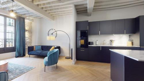 Il comprend une cuisine et un salon avec un canapé bleu. dans l'établissement Le petit Piron, à Dijon
