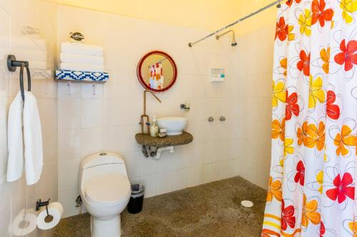 a bathroom with a toilet and a shower curtain at Casa Mar&iacute;a Resort in Bucer&iacute;as
