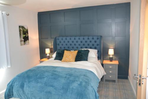 een bed met een blauw hoofdeinde in een slaapkamer bij The Thorold in Marston