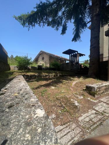 a view of a yard with a tree and a building at Casa Vacanza Regina in Roccaraso