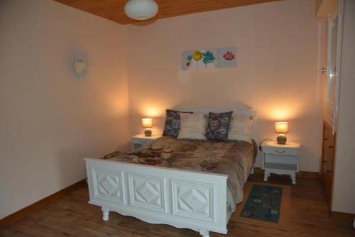 une chambre avec un lit blanc avec deux tables de nuit dans l'établissement Maison près des plages, à Tréffiagat