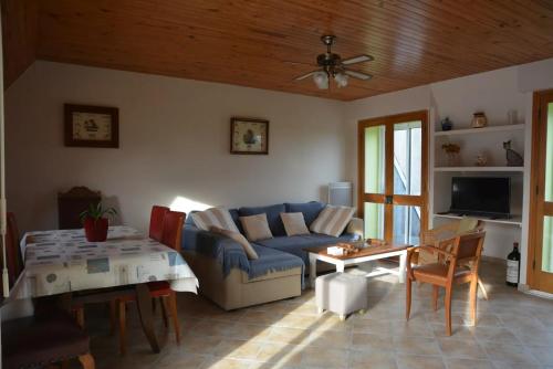 un salon avec un canapé bleu et une table dans l'établissement Maison près des plages, à Tréffiagat