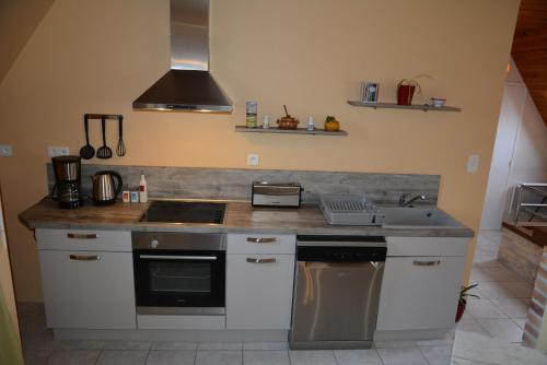 une cuisine avec un évier et une cuisinière four supérieur dans l'établissement Maison près des plages, à Tréffiagat