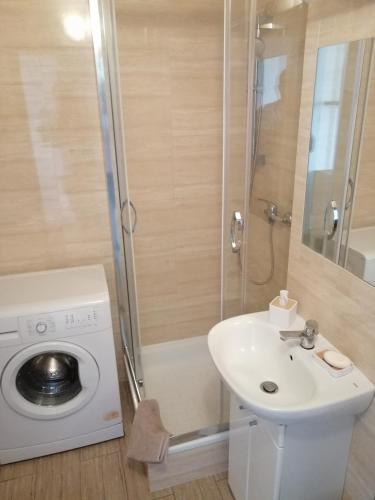 a bathroom with a sink and a washing machine at Studio Syreny in Warsaw