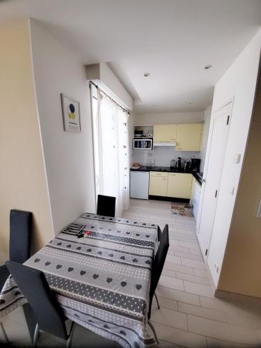 une pièce avec une table et des chaises et une cuisine dans l'établissement Nouveau monde, à La Rochelle