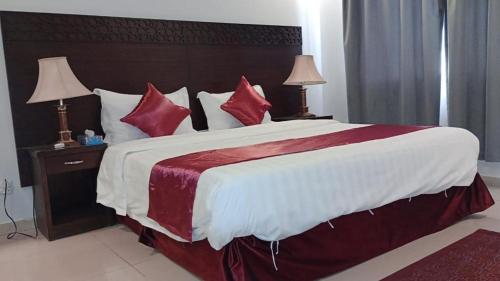 a bedroom with a large bed with red pillows at In Taibah in Al Madinah