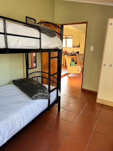 a bedroom with bunk beds and a living room at Tuinhuis in Oudtshoorn