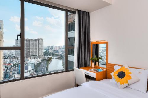 a bedroom with a large window with a bed and a desk at April Apartment in Ho Chi Minh City