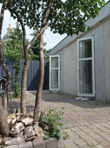 a house with a tree in front of it at House&House 84 in Petropavlovskaya Borshchagovka