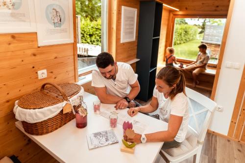 a man and a woman sitting at a table at Glamping Mountain Fairy Tale in Bistrica pri Tržiču