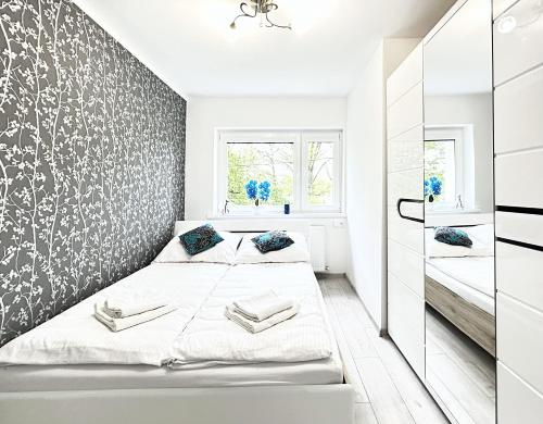 - 2 lits dans une petite chambre avec une fresque murale dans l'établissement Apartament LUX, à Jelenia Góra
