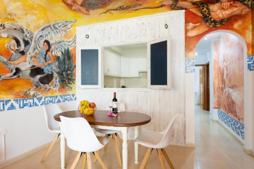 uma sala de jantar com mesa e cadeiras e um mural em EDEN RENTALS La Morada de Otazzo em La Orotava