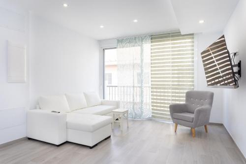 a white living room with a white couch and a chair at EDEN RENTALS Top City Center in Santa Cruz de Tenerife