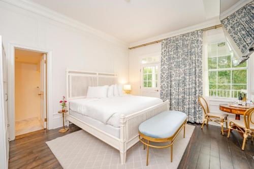 Kent Island Resort في Stevensville: غرفة نوم بيضاء مع سرير وطاولة
