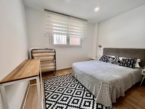 1 dormitorio con cama, mesa y ventana en Maximilian 3, en Madrid