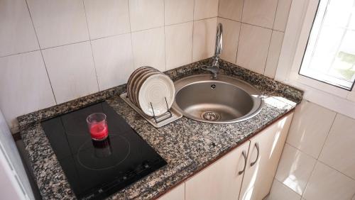 a kitchen counter with a sink and a candle at BUNGALOW LOS ARCOS in Maspalomas