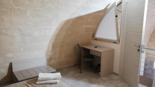 baño con lavabo y escritorio con espejo en B&B La Gemma dei Sassi, en Matera